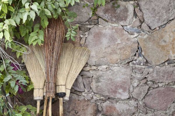 Mexico Brooms leaning against stone wall